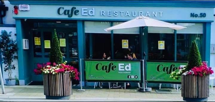 Cafe Ed on Patrick Street by day, with outdoor tables, planters and windbreaks.